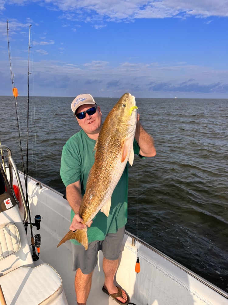 Angler holding a large redfish on a Reel Rusty charter.
